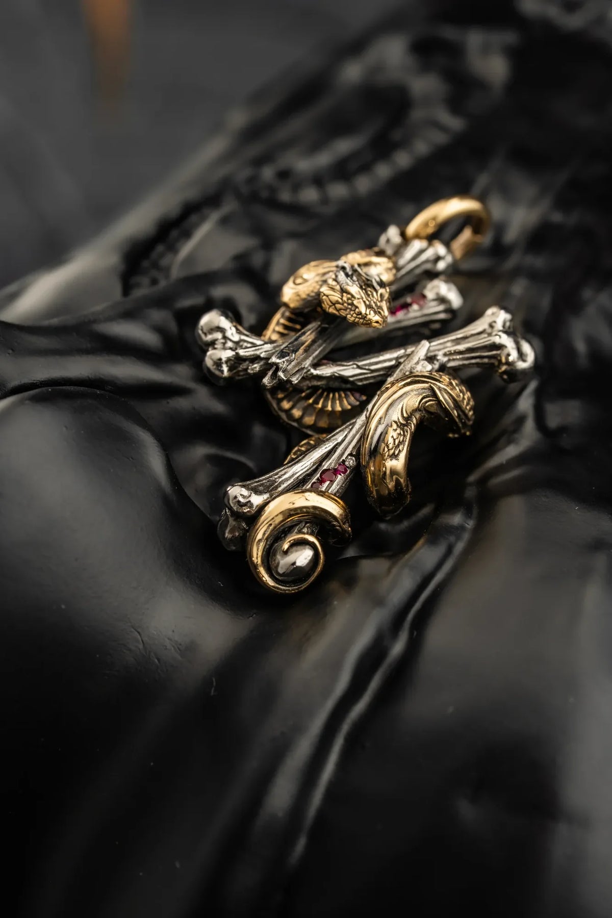 Still life of a WUYIN × EMLESS pendant combining serpent and bone forms