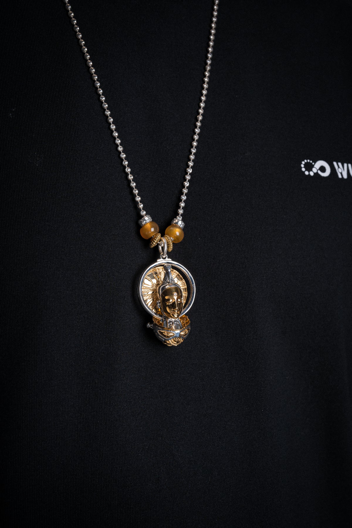 WUYIN sculptural pendant worn against a black shirt
