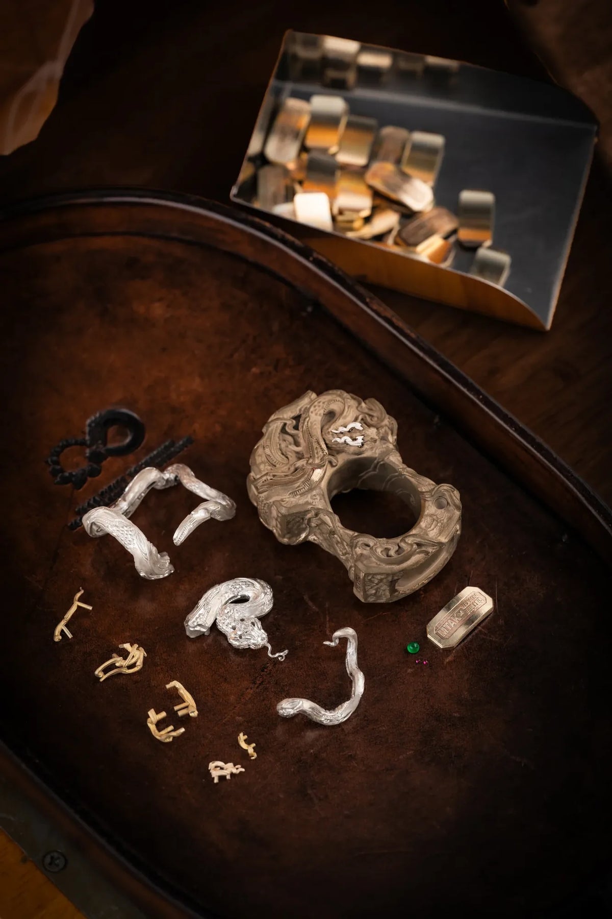 The ring-shaped body and metal serpent components of the Vine Serpent knuckle accessory displayed separately