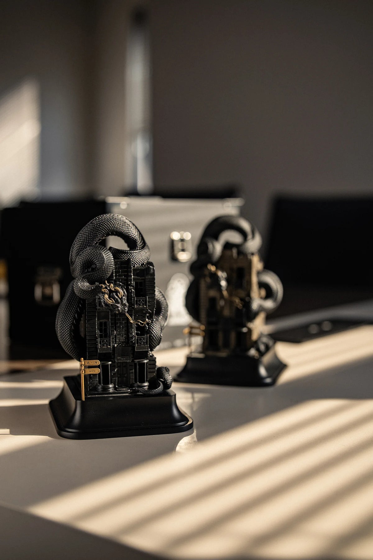 Two WUYIN x NOCAL:LOWCAL serpent house sculptures displayed in natural sunlight.