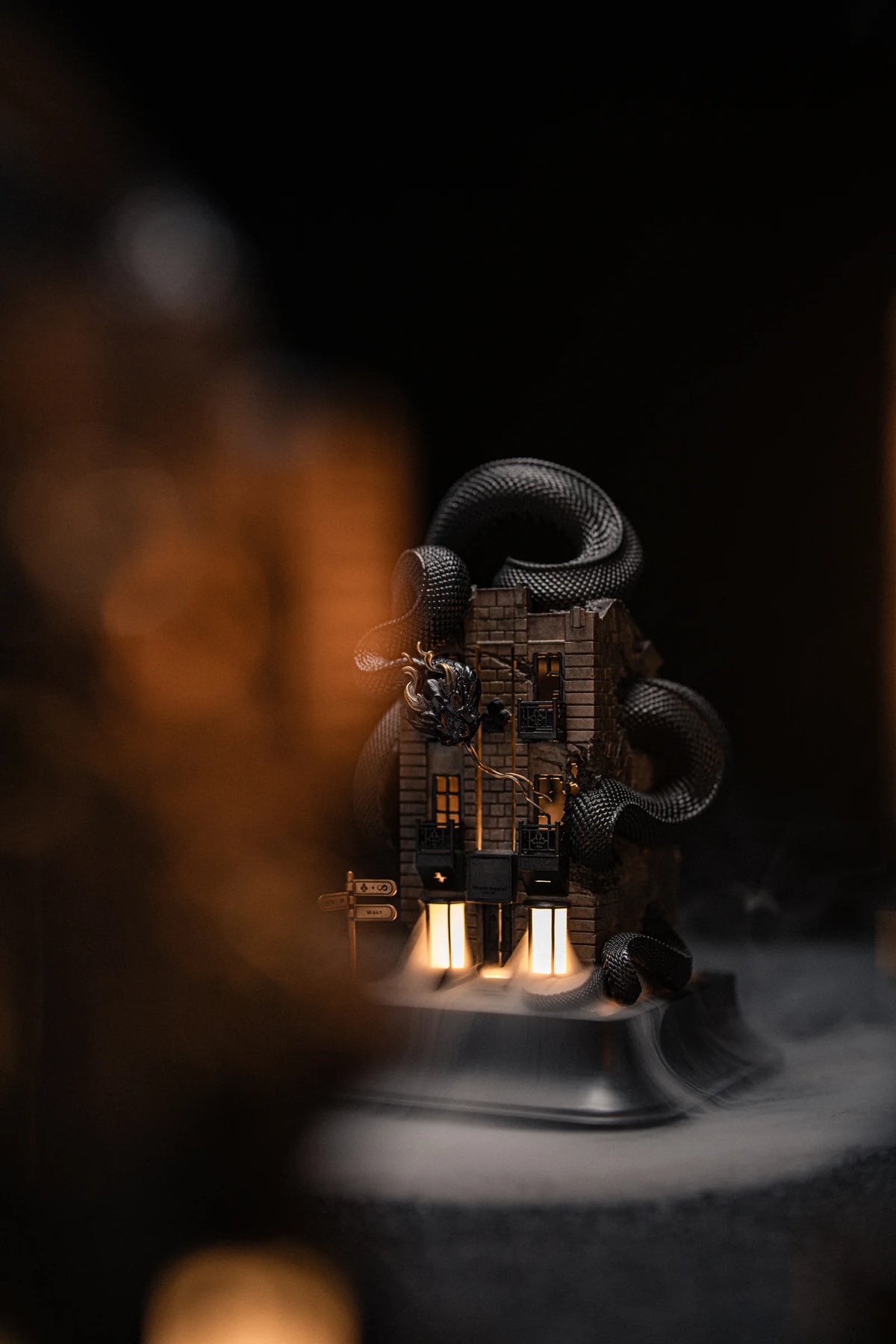Illuminated WUYIN x NOCAL:LOWCAL serpent house sculpture surrounded by drifting smoke.