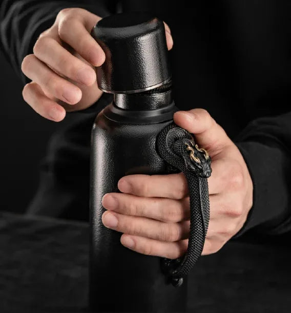 Xuegu × WUYIN Heirloom Teapot Mini in the Black Qilin edition, with hands holding its lid and serpent-shaped handle