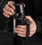 Xuegu × WUYIN Heirloom Teapot Mini in the Black Qilin edition, with hands holding its lid and serpent-shaped handle